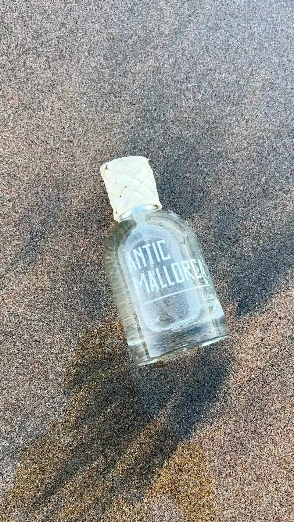 Perfume on sand with water